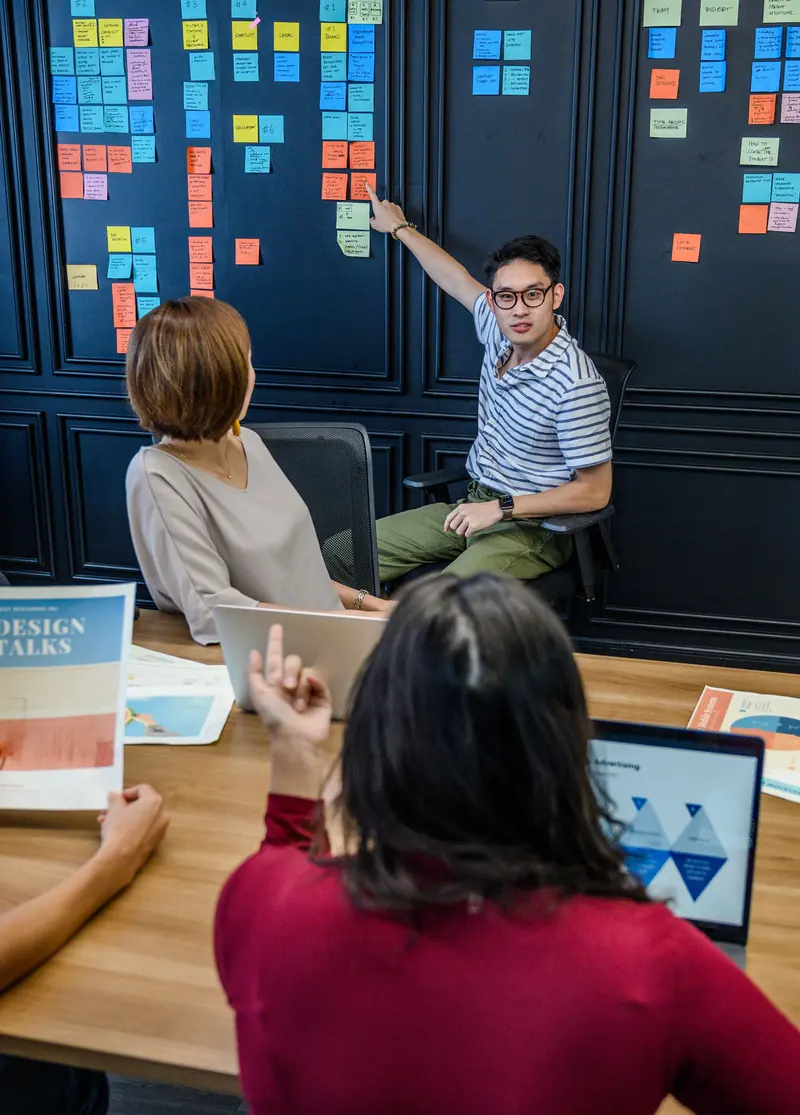 A team gathered at a wall of sticky notes during a planning workshop